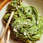 An overhead shot of Tallarines Verde in a bowl with a fork in it.