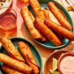 Flautas freshly made in some bowls with a dipping sauce on the side.