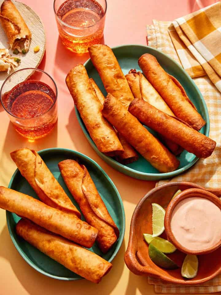 Flautas freshly made in some bowls with a dipping sauce on the side.