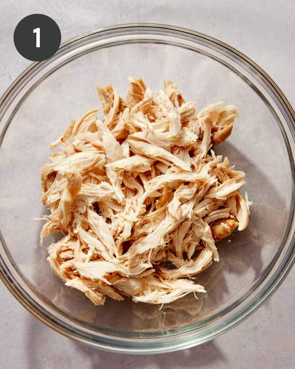 Shredded chicken in a glass bowl.