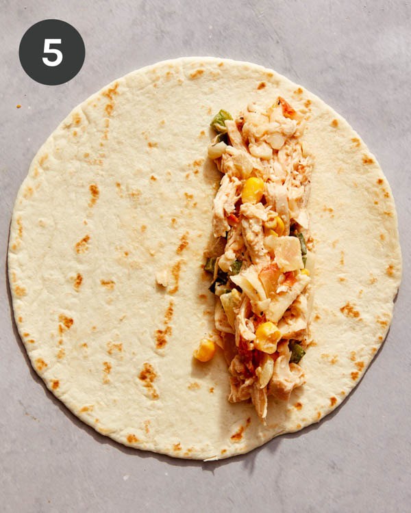 A flour tortilla with a chicken mixture formed onto it.