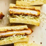 A close up of pork katsu sandwiches cut in half.