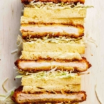 Stacked pork katsu sandwiches cut in half.