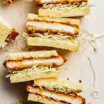 A close up of pork katsu sandwiches cut in half.