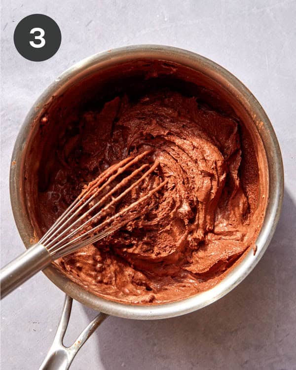 Cream added into dry ingredients and whisked together to make a chocolate sauce.