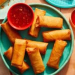 Vietnamese spring rolls on a platter with a bowl on sweet chili sauce.
