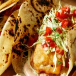Close up on a baja fish taco on a board.