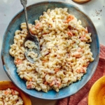 Hawaiian style macaroni salad in a bowl with serving bowls nearby.