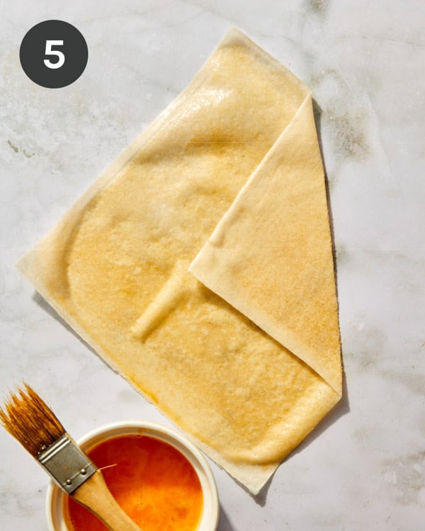 Spring roll wrapper brushed with an egg wash and folded over.