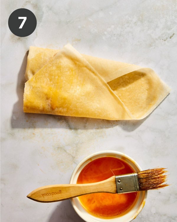 A spring roll wrapper in the process of being rolled up.