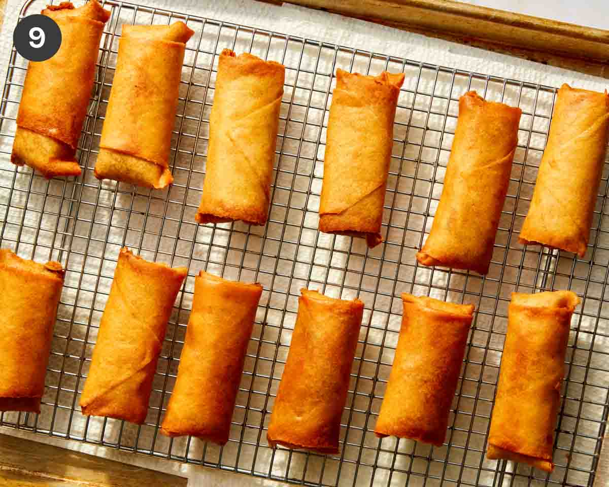 Fried spring rolls resting on a baking sheet.