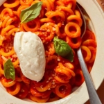 Spaghetti Ohs with ricotta on top and basil.