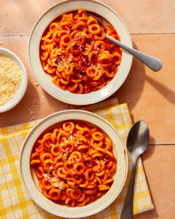 Homemade Spaghetti Os in two bowl with parmesan on the side.