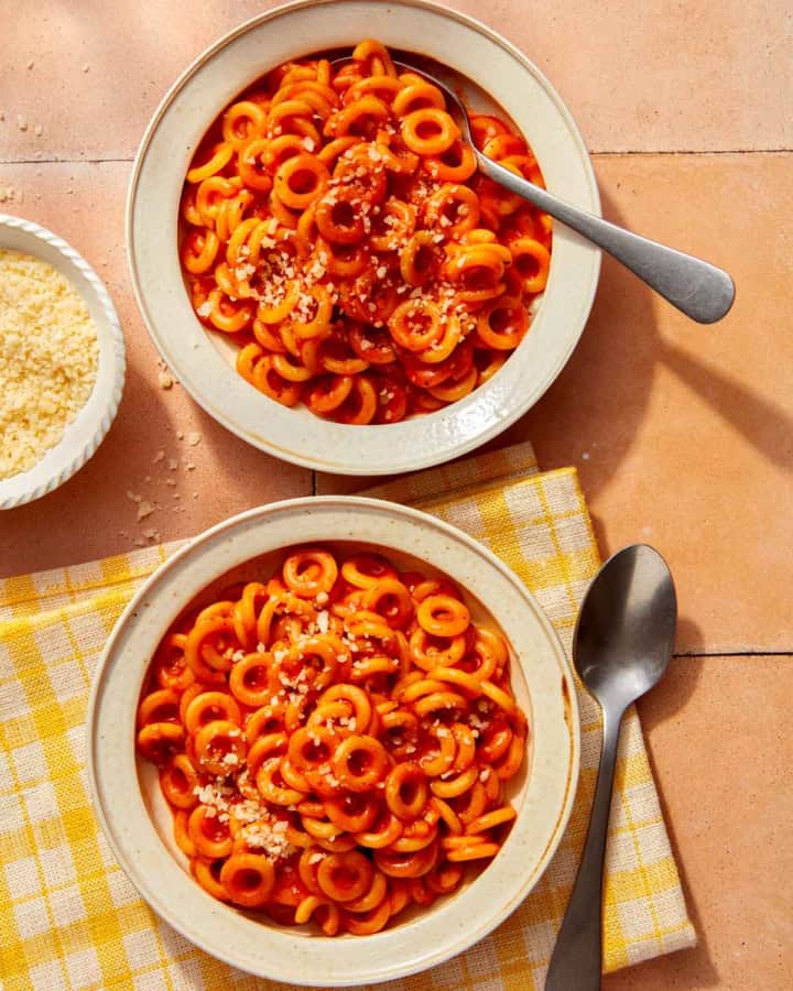 Homemade Spaghetti Os in two bowl with parmesan on the side.