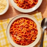 Homemade Spaghetti Os in two bowl with parmesan on the side.