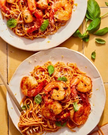 Tomato butter pasta on two plates with a fork in one.