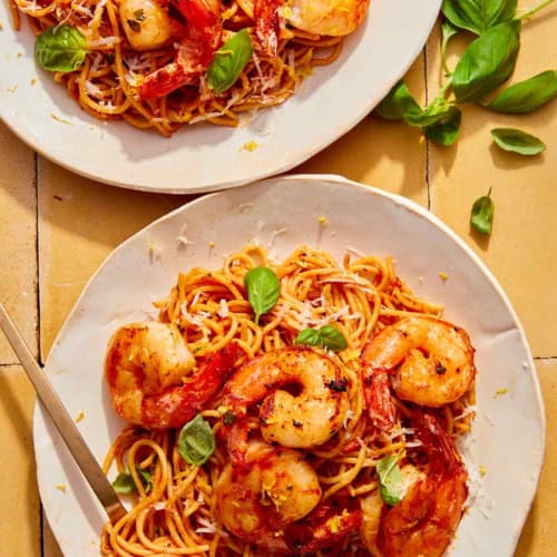 Tomato butter pasta on two plates with a fork in one.