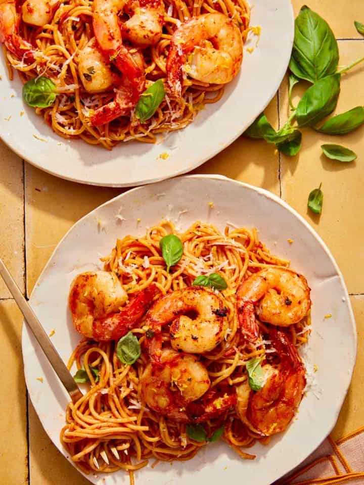 Tomato butter pasta on two plates with a fork in one.