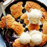 Blueberry cobbler recipe with a scoop taken out.