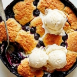 Blueberry cobbler recipe with a scoop taken out.