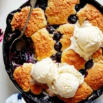 Blueberry cobbler recipe with a scoop taken out.
