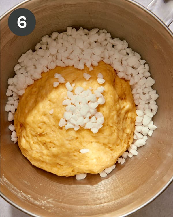 A ball of liege waffle dough with pearled sugar poured into the bowl.