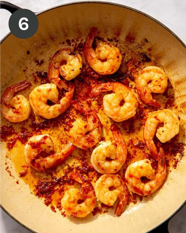 Shrimp being seared in a skillet.