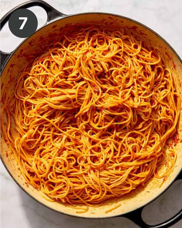 Tomato sauce and spaghetti tossed in a skillet.