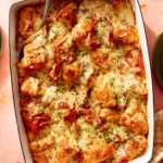 A casserole dish filled with ham and cheese croissant bake.