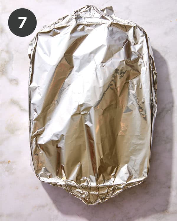 A ham and cheese croissant bake with tin foil on top.