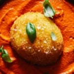 Fried burrata over romesco sauce in a skillet with bread.