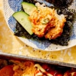 Sushi bake being served with cucumber slices.