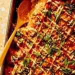 Close up on a baking dish of sushi bake recipe with a spoon in it.
