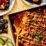 Salmon sushi bake in a baking dish with a spoon in it.