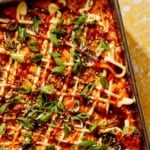 Close up on a baking dish of sushi bake recipe with a spoon in it.