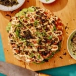 Sushi pizza on a cutting board.