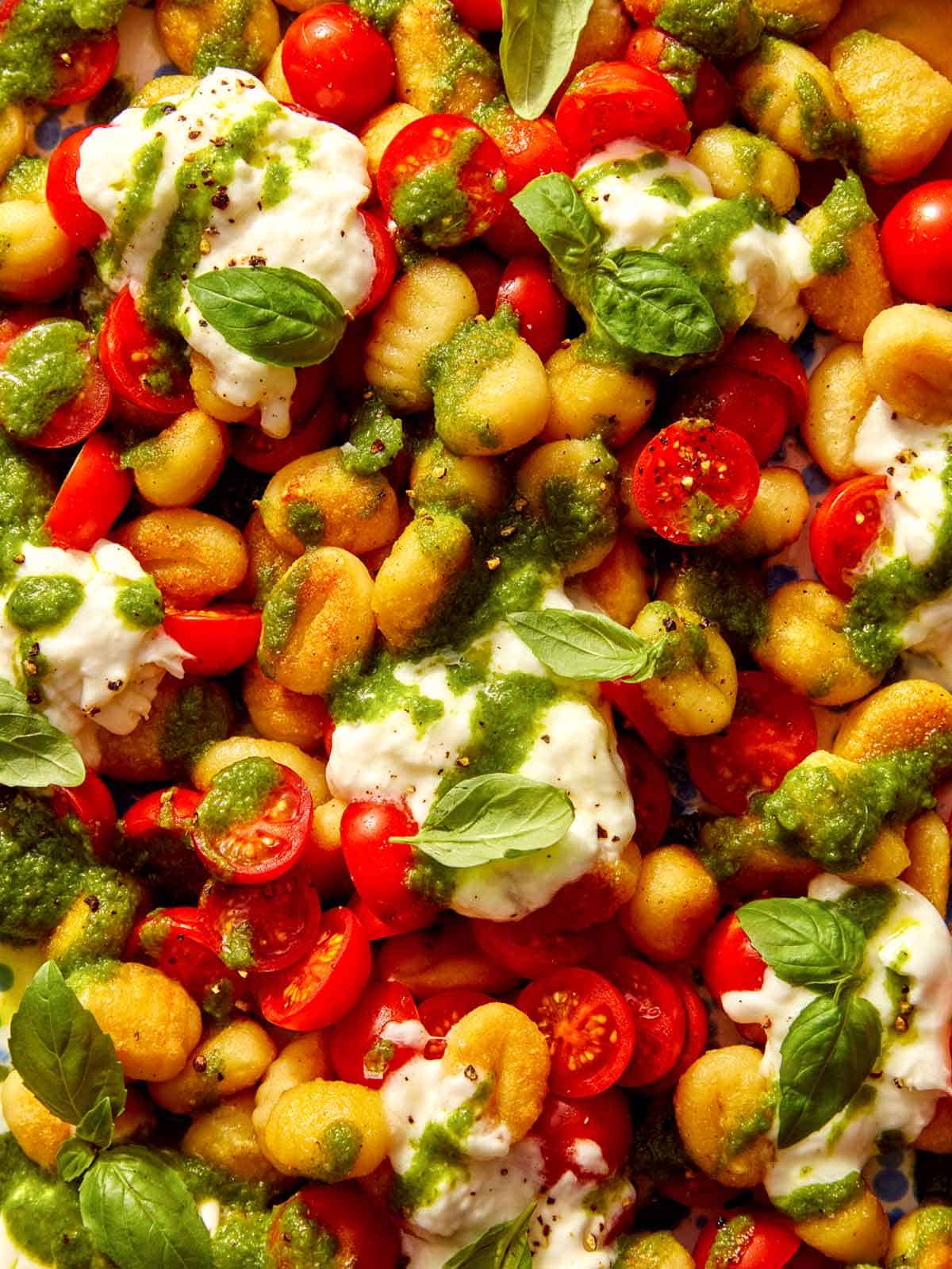 Caprese pan fried gnocchi on a platter up close.