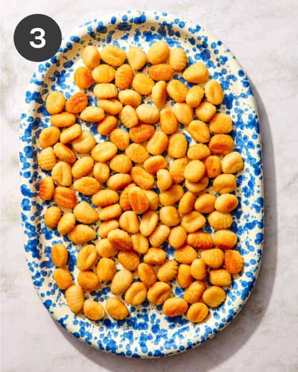 Pan fried gnocchi on a platter ready to be topped.