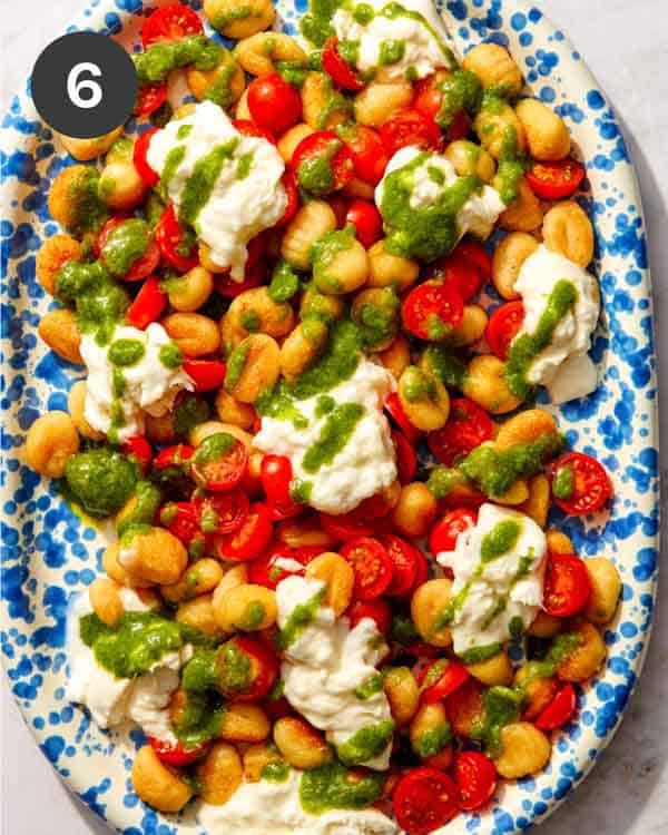 Pan fried gnocchi with basil vinaigrette on top.