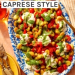 Caprese gnocchi on a platter with serving dishes on the side.