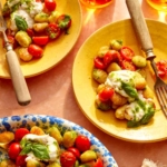 Plates with pan fried caprese gnocchi on them and forks.
