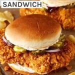 Pork Tenderloin sandwich on a cutting board with potato chips.