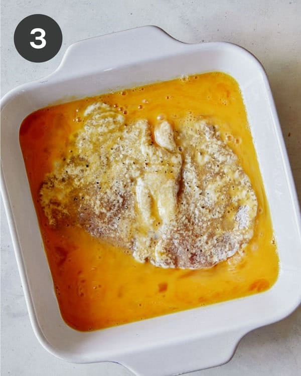 A pounded pork tenderloin in a dish with eggs.