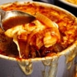 French onion soup recipe in a bowl with a spoon in it.